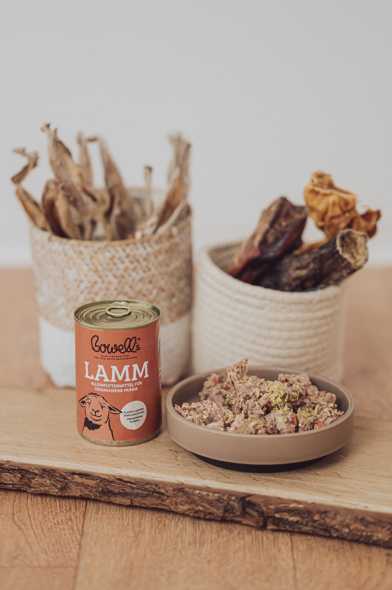 Bowell’s Lamm-Komplettmenü für Hunde neben Hundenapf und Kauartikeln
